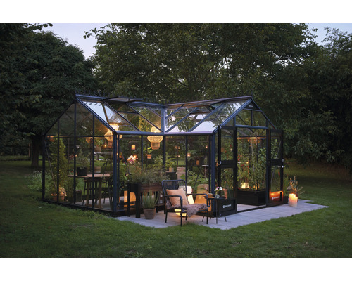 Gewächshaus mit Glaswänden und Pflanzen im Garten