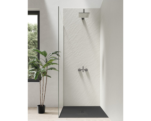 Begehbare Dusche mit Duschkopf und Armatur vor einer strukturierten Wand