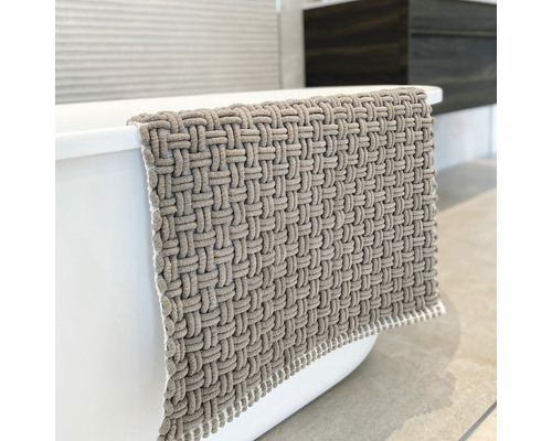 Geflochtener Badteppich aus Textil an einer Badewanne