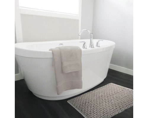 Freistehende Badewanne mit Armatur, Handtüchern und Badematte