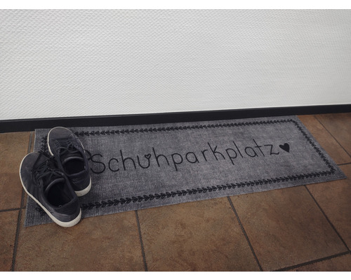 Fußmatte mit der Aufschrift Schuhparkplatz und Schuhen