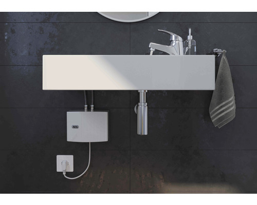 Modernes Badezimmer mit Aufsatzwaschbecken, Armatur, Handtuch und elektronischem Durchlauferhitzer von AEG