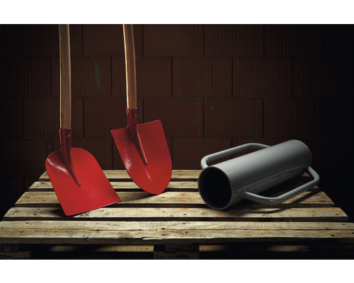 Zwei Spaten mit Holzstiel und ein Erdbohrer auf einer Palette.