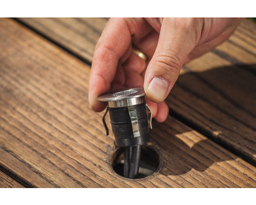 Einbauleuchte wird in eine Holzterrasse eingesetzt