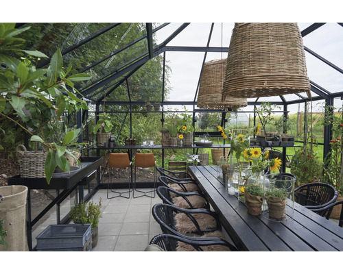 Gewächshaus mit Esstisch, Stühlen, Arbeitsfläche und Pflanzen