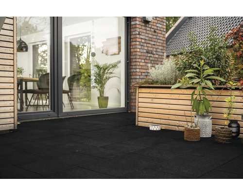 Terrasse mit schwarzen Terrassenplatten, Holzbepflanzung und Hausansicht