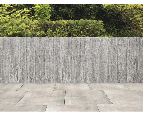 Garten mit Steinwand und Pflastersteinen