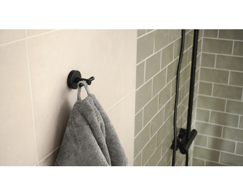 Doppelter Haken mit Handtuch an der Wand im Badezimmer
