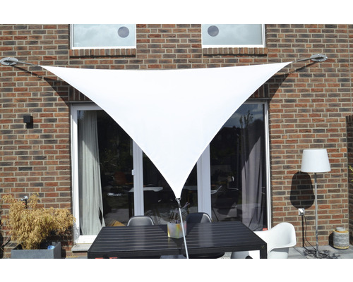 Dreieckiges Sonnensegel über einer Terrasse mit Tisch und Stühlen