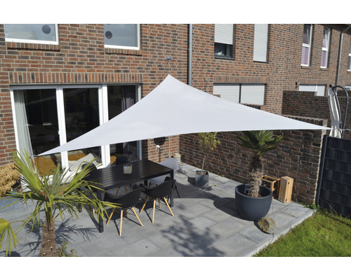 Terrasse mit Sonnensegel, Tisch und Stühlen vor Backsteinhaus