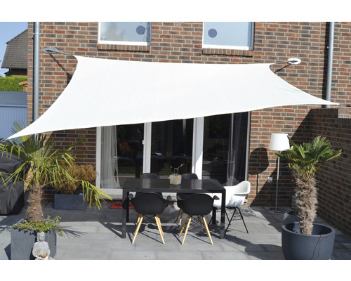 Weißes Sonnensegel über einer Terrasse mit Tisch und Stühlen