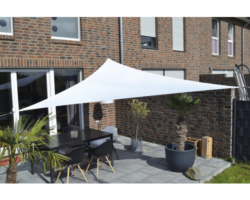 Außensitzbereich mit Sonnensegel, Tisch und Stühlen vor einem Backsteinhaus