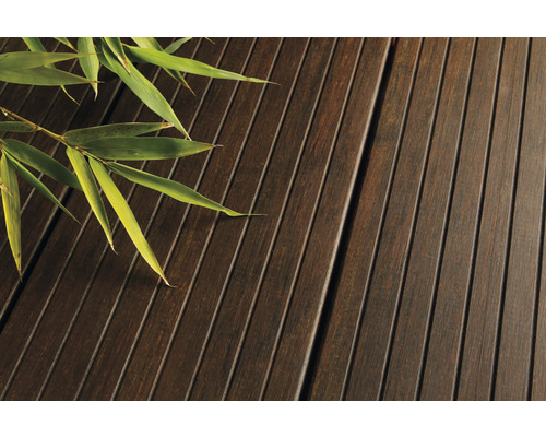 Nahaufnahme von Terrassendielen aus Holz mit Bambuszweig