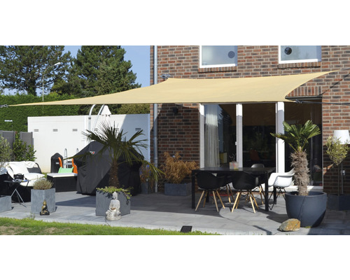 Terrasse mit Sonnensegel, Tisch und Stühlen sowie Pflanzenkübeln für den Außenbereich