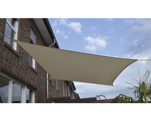Beige Sonnensegel an einem Backsteingebäude mit blauem Himmel