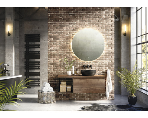 Helles Badezimmer mit freistehender Badewanne, Handtuchwärmer, Waschtisch mit Spiegel und Pflanzen für ein angenehmes Ambiente