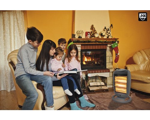 Eine Familie sitzt vor einem Kamin und einem Heizlüfter.