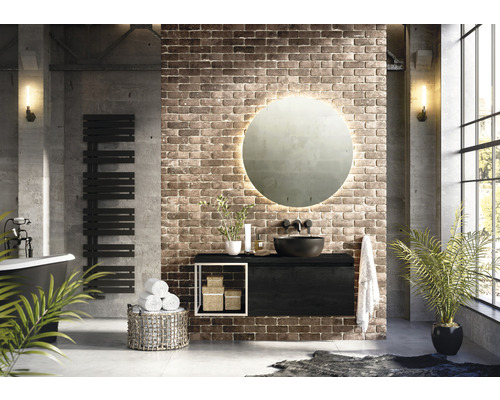 Badezimmer im Loftstil mit Waschtisch, Spiegel, Heizkörper und Badewanne vor einer Ziegelwand