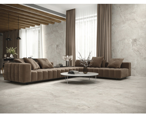 Wohnzimmer mit Sofa, Tisch und Fliesenboden.