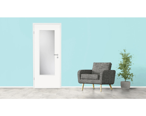 Zimmereinrichtung mit weißer Innentür mit Glaseinsatz, grauem Sessel und Zimmerpflanze