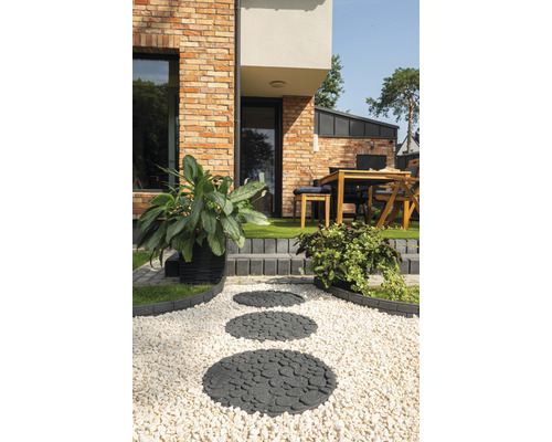 Gartenweg mit runden Trittsteinen und Zierkies vor einem Wohnhaus