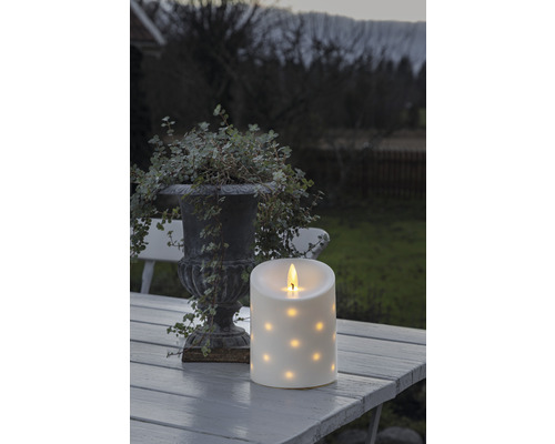 Dekorative LED Kerze mit Punktmuster auf einem Tisch im Freien