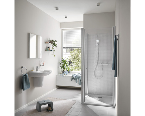 Helles Badezimmer mit Dusche, Waschbecken und Fenster für ein freundliches Ambiente