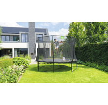 Trampolin mit Sicherheitsnetz im Garten mit springendem Kind