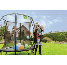 Familie spielt auf einem runden Gartentrampolin mit Sicherheitsnetz und Leiter auf Rasen.