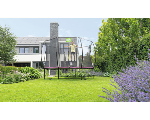 Trampolin mit Sicherheitsnetz im Garten mit springendem Kind