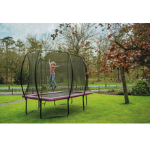 Mädchen springt auf Gartentrampolin mit Sicherheitsnetz