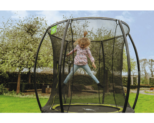 Mädchen springt auf Gartentrampolin mit Sicherheitsnetz