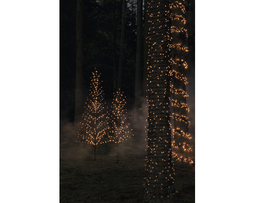 Dekorative Bäume und Baumstämme mit Lichterketten im Garten