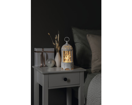 Dekoratives Nachtkästchen mit Geschenk, Vase, Zierkugel und beleuchteter Schneekugel