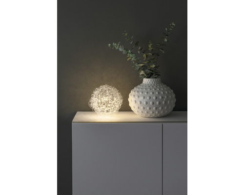 Dekorative Szene mit Kugelleuchte und Vase auf einem Schrank