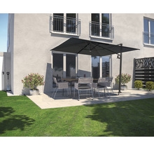 Terrasse mit Gartenschirm, Tisch und Stühlen vor einem Haus