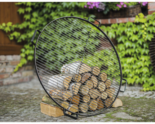 Runder Grillrost mit Brennholz im Garten