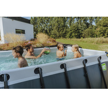 Familie mit Kindern spielt im rechteckigen Aufstellpool im Garten.