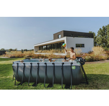 Familie mit Aufstellpool im Garten vor einem Wohnhaus