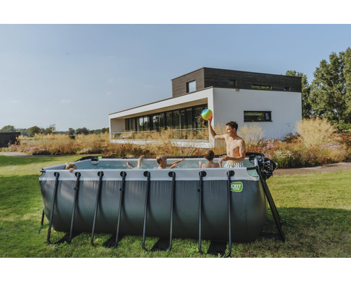 Familie mit Aufstellpool im Garten vor einem Wohnhaus