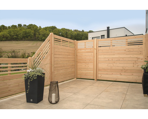 Terrasse mit Holzzaun, Pflanzgefäßen und Windlicht