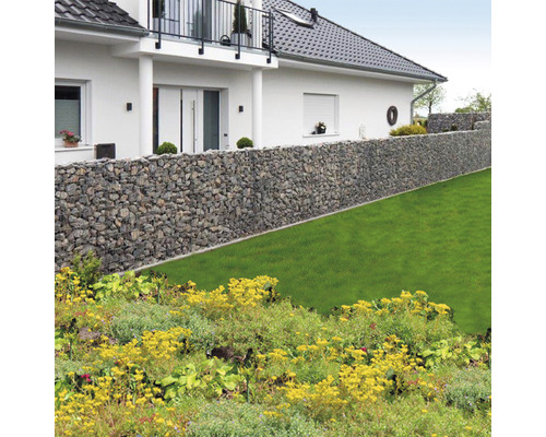 Gabionenwand vor einem Haus mit Gartenanlage
