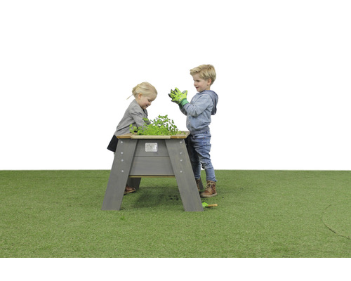 Kinder spielen an einem Hochbeet aus Holz im Garten.