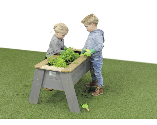 Zwei Kinder gärtnern in einem Hochbeet aus Holz im Garten.