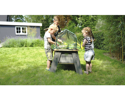 Drei Kinder spielen mit einem EXIT-Hochbeet im Garten.