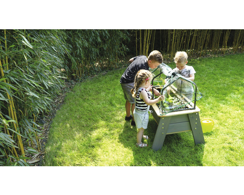 Kinder beim Gärtnern mit einem Hochbeet im Garten.
