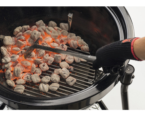 Grill mit glühenden Grillbriketts und Grillzange