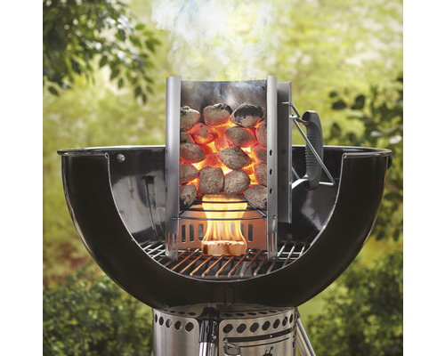 Anzündkamin mit glühenden Grillbriketts auf einem Holzkohlegrill