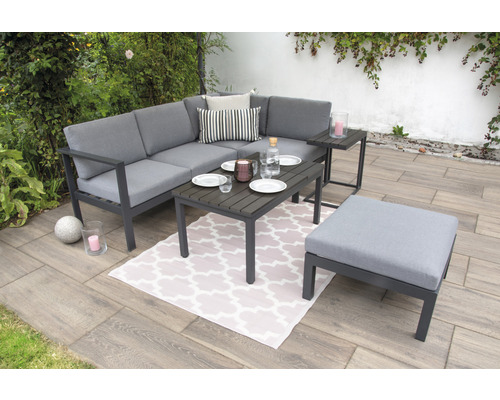 Gartenlounge-Set mit Ecksofa, Tisch und Hocker auf einer Terrasse