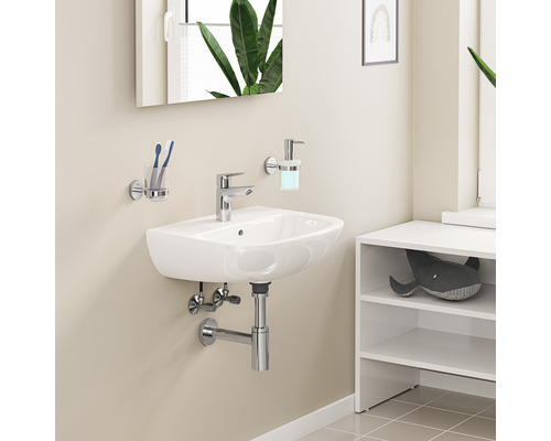 Waschbecken im Badezimmer mit Armatur, Seifenspender und Zahnputzbecher